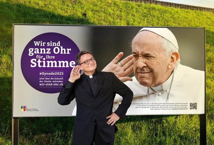 Bischof Felix Gmür vor Kampagnenplakat